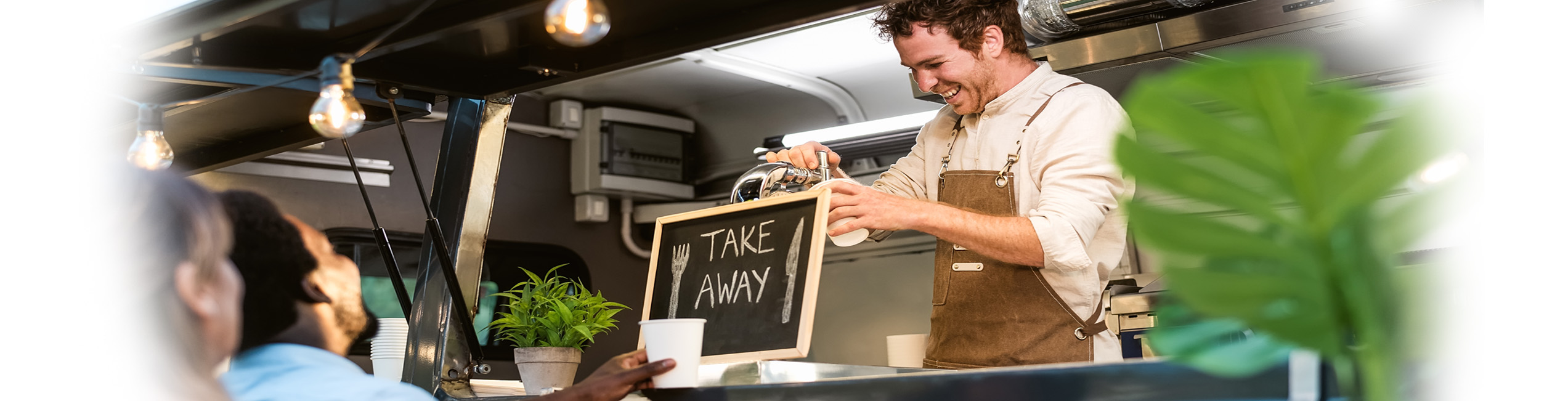 Protect your mobile catering business with comprehensive liability, van and business insurance. Mobile catering van banner, showing a customer purchasing food from a takeaway food van.