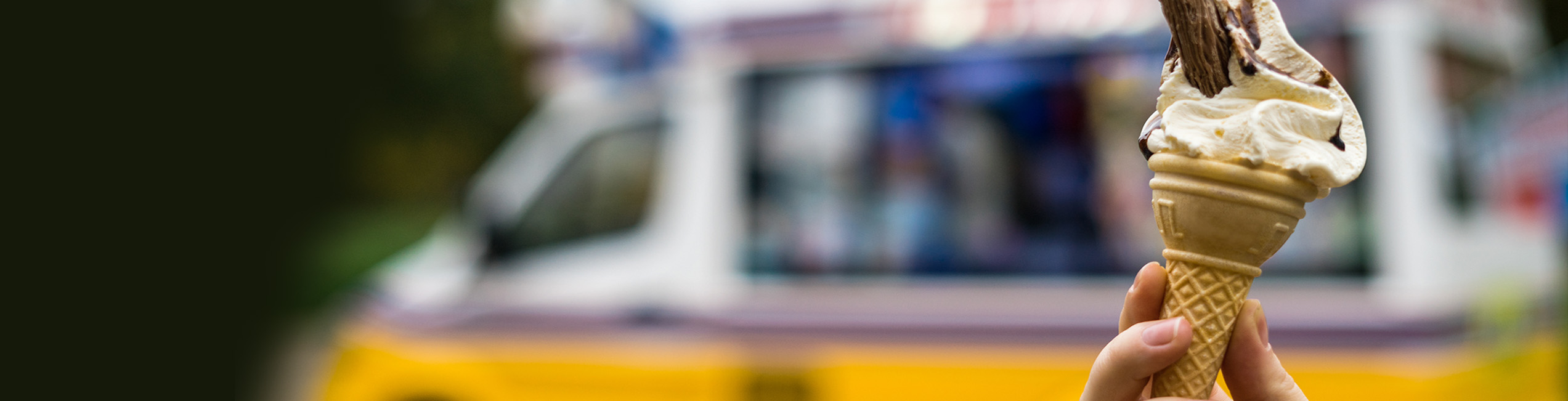 Protect your ice cream van business with comprehensive liability, van and business insurance. Ice cream van banner, showing an ice cream van with a 99 ice cream in the foreground